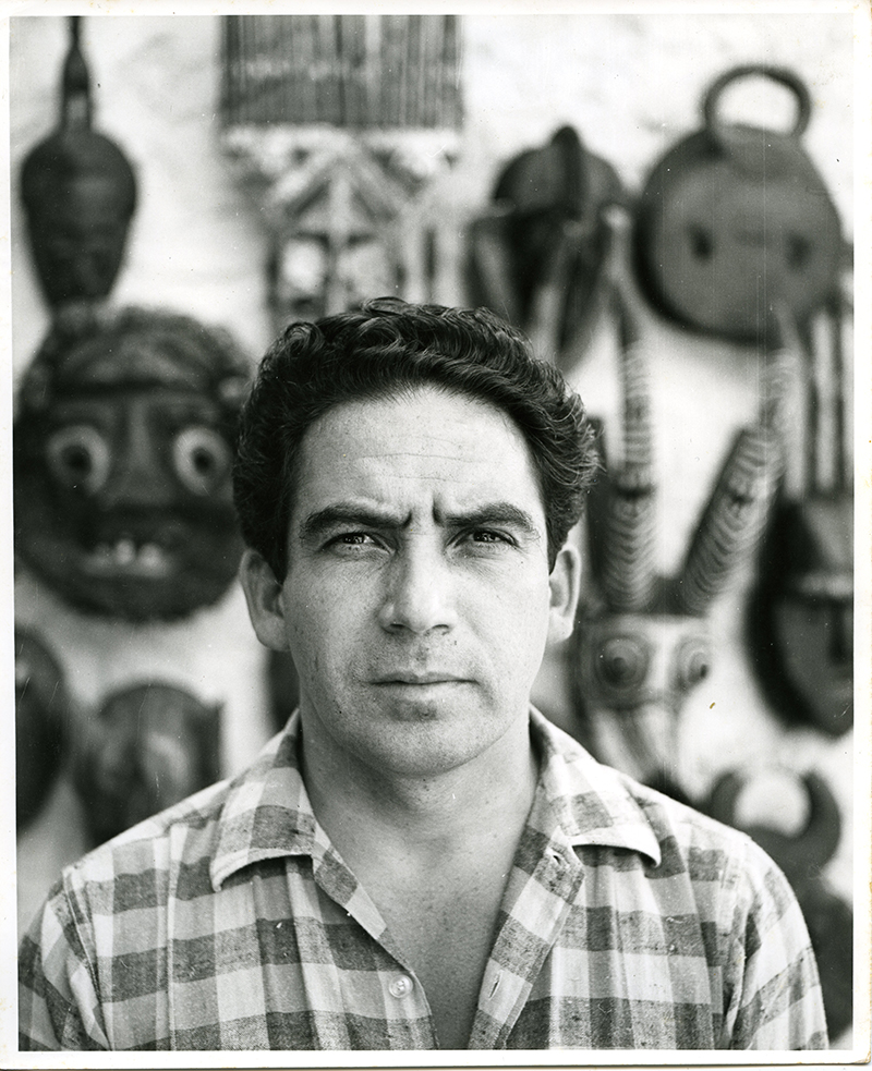 Oswaldo Vigas frente a su coleccion de mascaras africanas. Merida Venezuela 1966