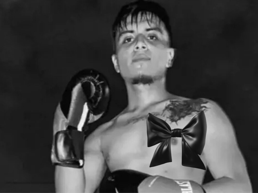 oxeador Josué David Hernández posando en blanco y negro con guantes de boxeo y mirando fijamente a la cámara.