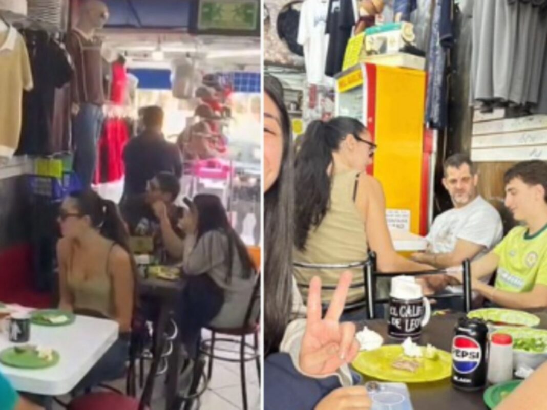 Dua Lipa sentada junto a un acompañante en la taquería El Califa de León en Ciudad de México, disfrutando de unos tacos. El lugar se ve concurrido y casual.