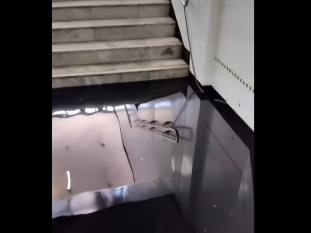 Pasillo y escaleras con graves Inundaciones en el Metro CDMX que reflejan el techo debido al agua estancada por falta de desagüe.